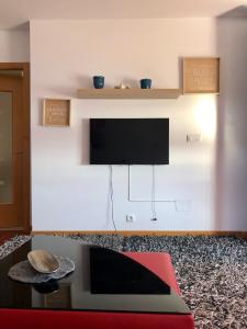 uma sala de estar com uma televisão de ecrã plano e uma mesa em Apartamento exclusivo con vistas al mar em Outes
