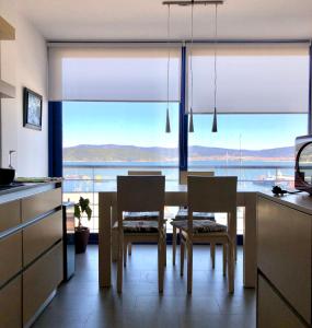 uma cozinha com mesa e cadeiras e uma grande janela em Apartamento exclusivo con vistas al mar em Outes
