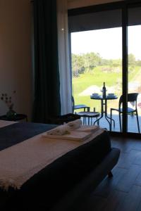 a bedroom with a bed and a view of a table at Zambujal Suites in Sesimbra