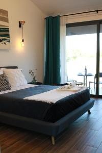 a large bed in a room with a large window at Zambujal Suites in Sesimbra