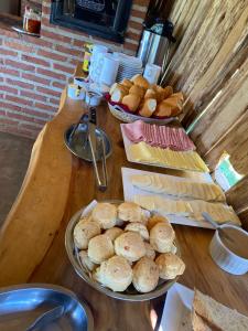 a wooden table with two plates of bread and pastries at pousada do caneca in Senador Amaral