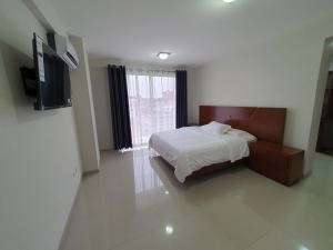 a bedroom with a bed and a large window at Alissthon in Santa Cruz de la Sierra