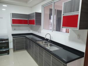a kitchen with red and white cabinets and a sink at Alissthon in Santa Cruz de la Sierra