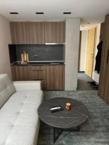 a living room with a white couch and a table at Woodside Kopaonik Duplex 003 in Kopaonik