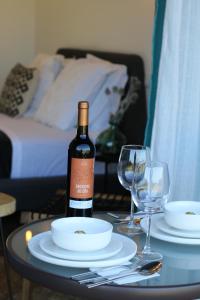 a bottle of wine sitting on a table with two glasses at Zambujal Suites in Sesimbra