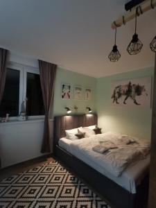 a bedroom with a large bed and two windows at Kai Apartman in Kopaonik