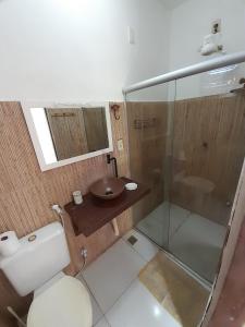 uma casa de banho com um WC, um lavatório e um chuveiro em Suites na Vila em Maraú