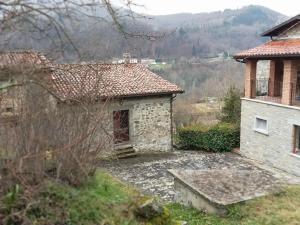 uma casa de pedra com um banco à frente em bacciano casa vacanze em Poggio