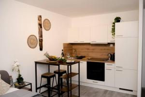 uma cozinha com armários brancos e uma pequena mesa com bancos em Entire Tulum Apartment, in the Center of Vienna em Viena