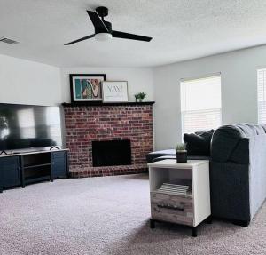 a living room with a couch and a fireplace at Cozy 3 Bedroom House with Beautiful Fireplace in McKinney