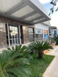 a building with palm trees in front of it at STAY Blend SmartStyle in Goiânia