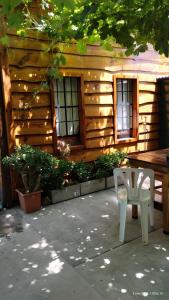 Cabaña de madera con mesa y silla blanca en El Nogal Viedma en Viedma