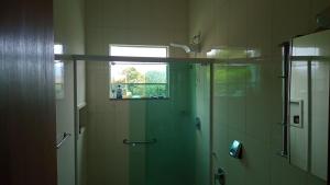 W łazience znajduje się prysznic ze szklanymi drzwiami. w obiekcie Casa da Serra w mieście Pouso Alto