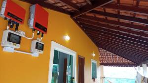 żółta ściana z dwoma monitorami na ścianie w obiekcie Casa da Serra w mieście Pouso Alto