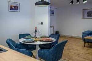 comedor con mesa y sillas azules en Five Stars Apartment, en Timisoara