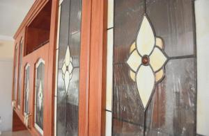 a wooden cabinet with stained glass windows on it at Villa Csilla elegant house in Érd