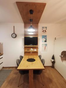 a dining room with a table and a tv at Kai Apartman in Kopaonik