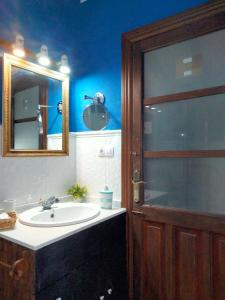 a bathroom with a sink and a mirror and a shower at Hostal los Aromas in Villena