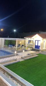 a house with a lawn in front of it at night at شاليه الشروق in Ash Shuqra