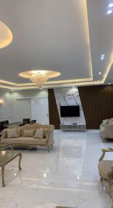 una gran sala de estar con sofás y TV. en شاليه الشروق en Ash Shuqra