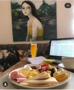 um prato de comida de pequeno-almoço numa mesa com um computador portátil em La Casa de Manuel Casa-Boutique em Loja