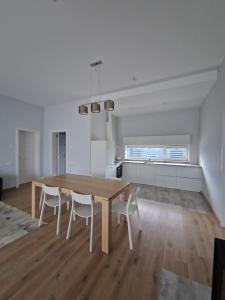 a kitchen and dining room with a wooden table and chairs at IG House in Druskininkai