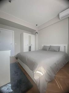 a white bedroom with a large white bed at Central Apartment in Varna in Varna City