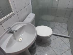 een badkamer met een wit toilet en een wastafel bij Apartamento em Cabo Frio com Wi-fi in Cabo Frio