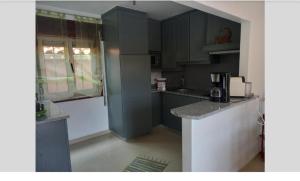 uma cozinha com armários cinzentos e uma bancada em LOFT Aver-o-mar 2 min a pé da praia na Póvoa do Varzim