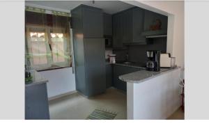 a kitchen with gray cabinets and a counter top at LOFT Aver-o-mar 2 min a pé da praia in Póvoa de Varzim