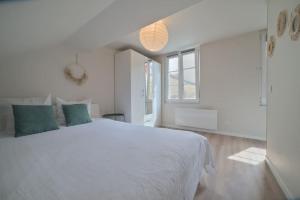 ein weißes Schlafzimmer mit einem großen Bett und einem Fenster in der Unterkunft Le studio de la république - 2P - Hyper centre Metz in Metz + 6 Fotos