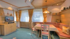 a dining room with a table and a couch at Sportalm Apartments in Leutasch +4 photos