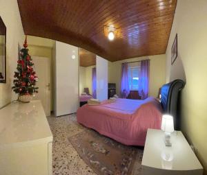 ein Schlafzimmer mit einem Weihnachtsbaum und einem Bett in der Unterkunft AL CAMPANILE centro storico ampio luminoso e panoramico appartamento trilocale in Carsoli