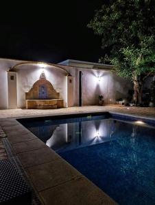 una piscina en un patio trasero por la noche en casa de vicky, en El Puerto de Santa María