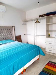 坎昆Bella Casa Familiar的一间卧室，里面有一张床，铺着蓝色被子。 更多14张照片