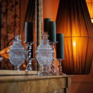 un groupe de vases en verre avec des bougies sur une table dans l'établissement Domaine de Locguénolé & Spa - Relais & Chateaux, à Kervignac