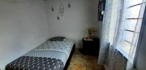 Habitación pequeña con cama y ventana en Comodo Apartamento en Medellin, en Medellín