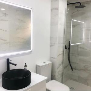 a bathroom with a black sink and a shower at Caparica Beach House in Costa da Caparica