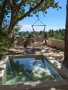a hammock hanging from a tree next to a pool at YAM HOTEL in Mazunte