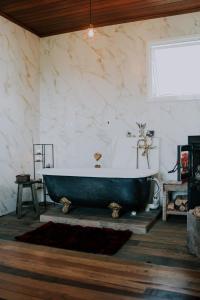 - une baignoire dans une chambre dotée d'un mur en marbre dans l'établissement Schatz Chalé Witmarsum, à Palmeira