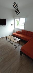 a living room with a red couch and a coffee table at Colores De La Quebrada in Cafayate