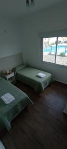 a room with two beds and a window at Colores De La Quebrada in Cafayate +11 photos