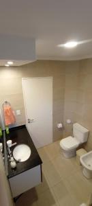 a bathroom with a toilet and a sink at Colores De La Quebrada in Cafayate