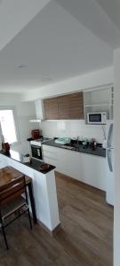 a kitchen with white cabinets and a table in it at Colores De La Quebrada in Cafayate