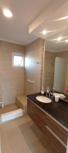 a bathroom with a sink and a large mirror at Colores De La Quebrada in Cafayate