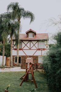 une maison avec des palmiers devant elle dans l'établissement Schatz Chalé Witmarsum, à Palmeira