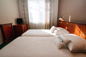 a hotel room with two beds and a window at Union Hotel Prague in Prague