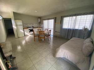 1 dormitorio con 1 cama, mesa y sillas en Aires Casas de campo en Villa Santa Cruz del Lago