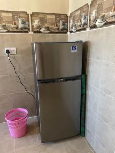 a stainless steel refrigerator in a corner of a kitchen at Apartment in Bayt Al Jabal شقة في بيت الجبل in Sayq