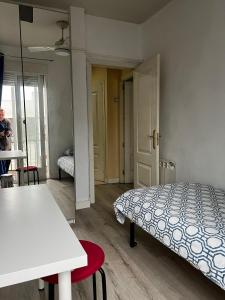 Habitación con cama, mesa y ventana en Habitaciónes Luminosas y acogedoras, en Madrid